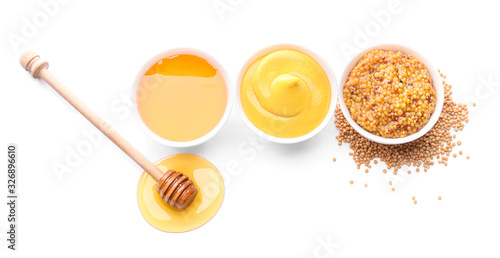 Bowls of honey, mustard and sauce on white background