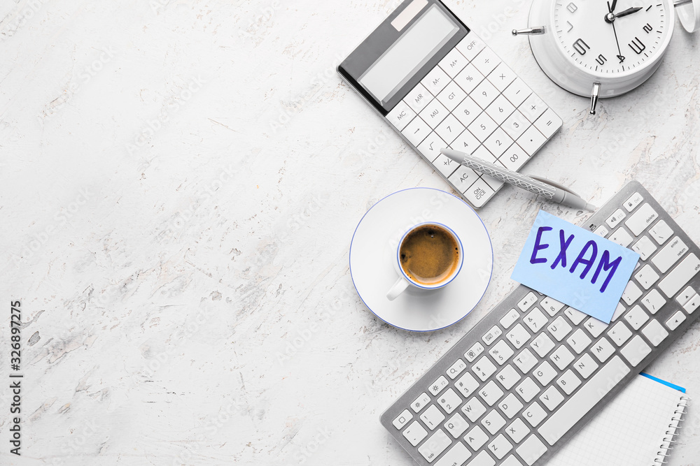 Cup of coffee with computer keyboard, alarm clock, calculator and paper sheet with text EXAMS on white background Cup of coffee with computer keyboard, alarm clock, calculator and paper sheet with text EXAMS on white background