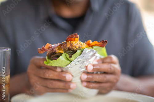 Obraz na plátně African American man eating a burger without a bun.
