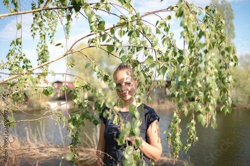 Portrait of a young woman behind tree leaves