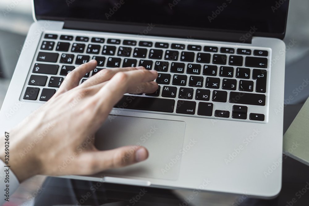 Man hands typing on laptop keyboard in sunny office, business and technology concept. Close up Man hands typing on laptop keyboard in sunny office, business and technology concept. Close up