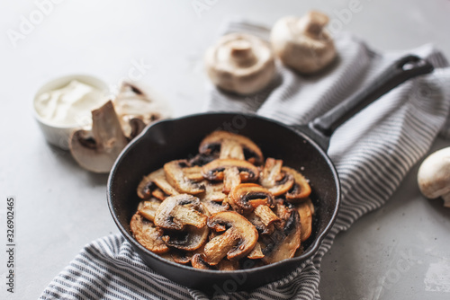 Delicious fried mushrooms with flat bread and herbs on the wooden table