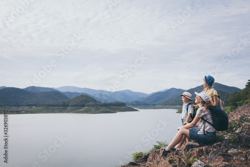 Happy family standing near the lake at the day time. © altanaka