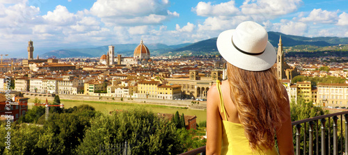 Woman in yellow dress and hat looks at stunning panoramic view of Florence, Italy. Happy pretty girl in Tuscany with Florence cityscape, banner view. photo