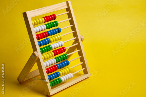 Abacus at yellow background. Shopping, personal finances, money spendings concept