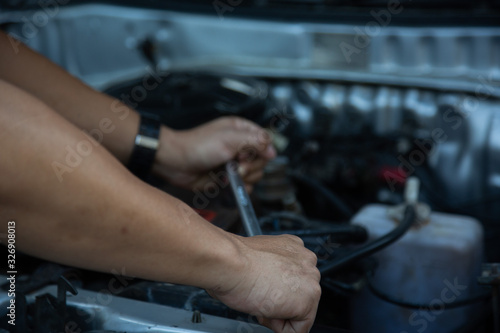 Men are using hands to change the car engine oil to extend the service life. © weerachai