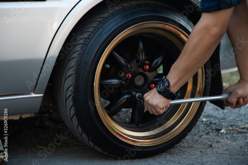 A man using a hand to change a wheel because of a tire bomb