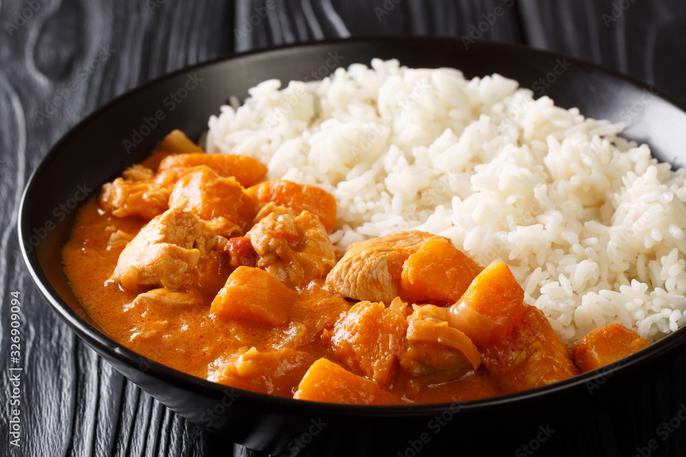 Domoda, a delicious peanut stew, is the national dish of Gambia. The rich and delicious vegetable and meat stew is served over rice close-up in a plate. Horizontal Domoda, a delicious peanut stew, is the national dish of Gambia. The rich and delicious vegetable and meat stew is served over rice close-up in a plate. Horizontal