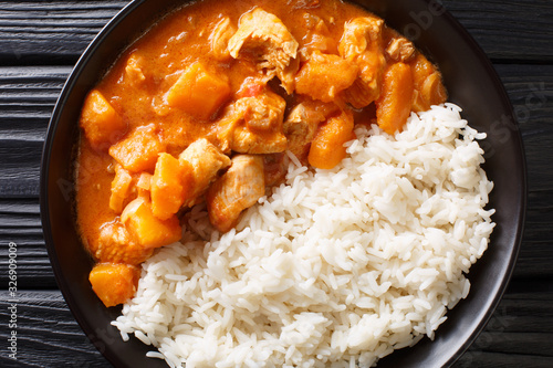 Domoda is the national dish of Gambia, a peanut stew made with meat pumpkin and served over fluffy rice close-up in a plate. Horizontal top view