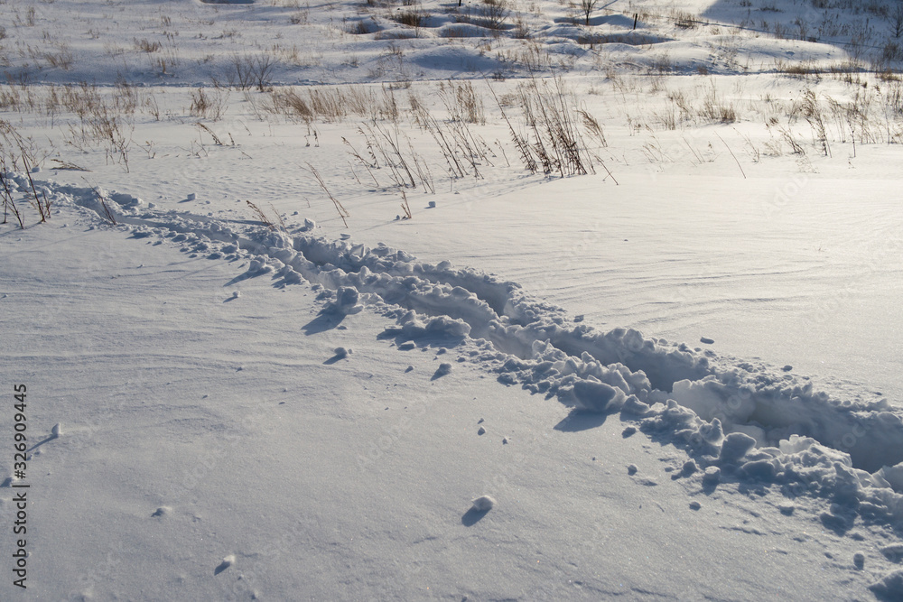 The snowy path in the field. The snowy path.