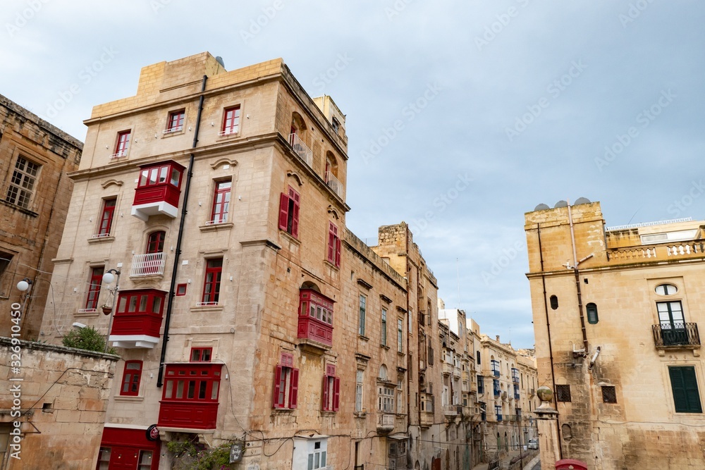 The very old houses with red windows and balconies at Liesse street in Valletta, Malta