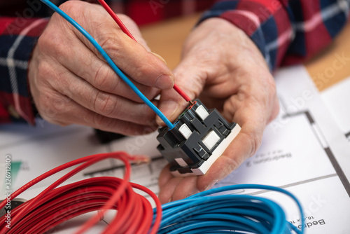 Electrician connecting a wire into a power socket