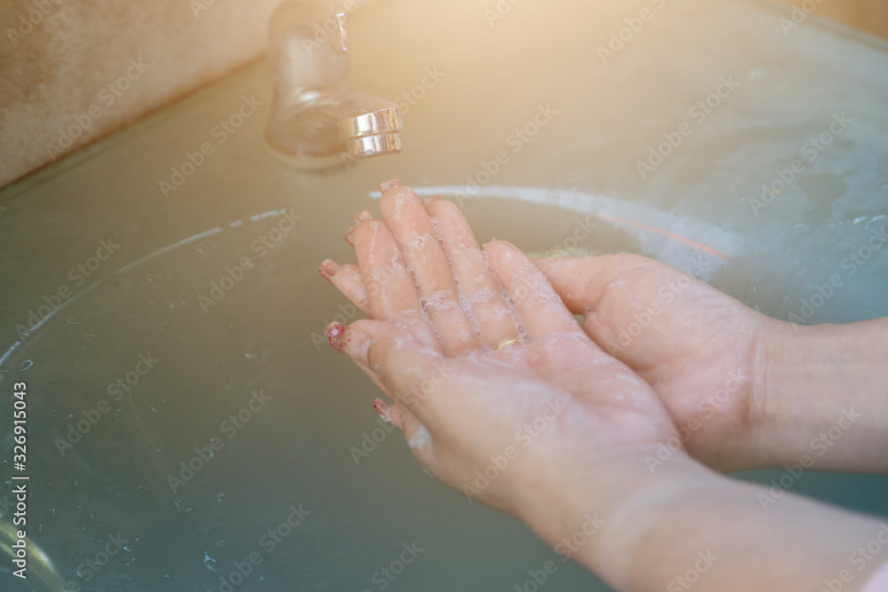 Fototapeta premium Women wash their hands properly before eating with water tap