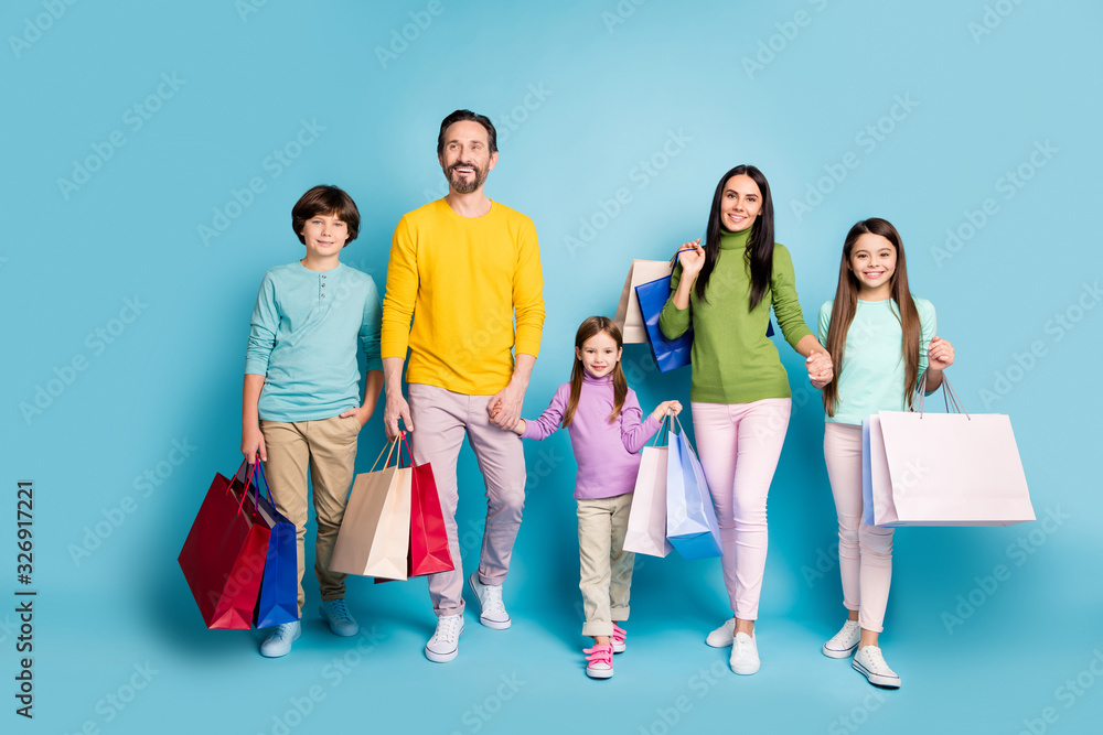 Full length body size view of nice attractive lovely glad cheerful family carrying bags new things clothes spending day black Friday isolated on bright vivid shine vibrant blue color background Full length body size view of nice attractive lovely glad cheerful family carrying bags new things clothes spending day black Friday isolated on bright vivid shine vibrant blue color background
