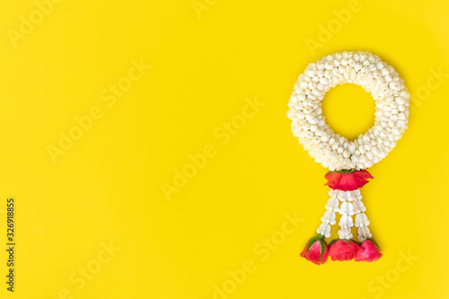 Beautiful thai traditional jasmine garland and rose on yellow background. Symbol of Mother’s day in Thailand. Thai garland made of jasmine and rose for mom.