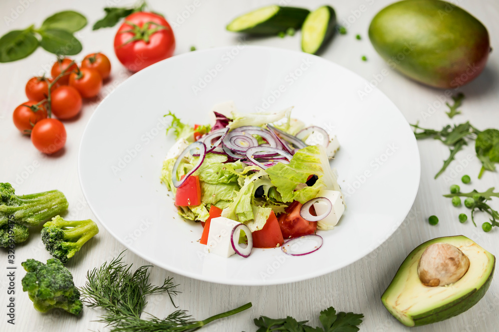 fresh vegetable salad light salad on a large white plate on a white table with a composition of tomatoes, avocado, parsley, cucumber, peas, broccoli fresh vegetable salad light salad on a large white plate on a white table with a composition of tomatoes, avocado, parsley, cucumber, peas, broccoli