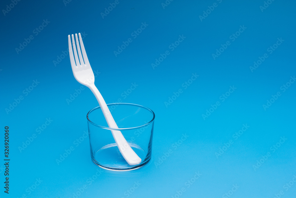 Teaspoon and plastic fork and glass tumbler Teaspoon and plastic fork and glass tumbler