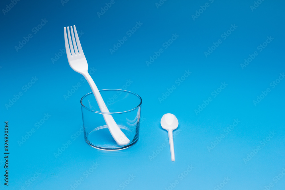 Teaspoon and plastic fork and glass tumbler Teaspoon and plastic fork and glass tumbler