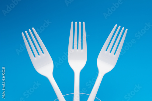 Teaspoon and plastic fork and glass tumbler