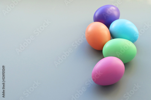 A group of Easter colored eggs painted with bright colors on a gray background. Selective focus.Copy space