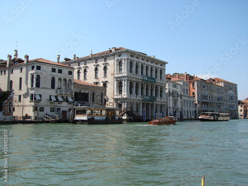 The beauty of the unique Venetian architecture surrounded by water streets and avenues against the backdrop of a clear blue summer sky.