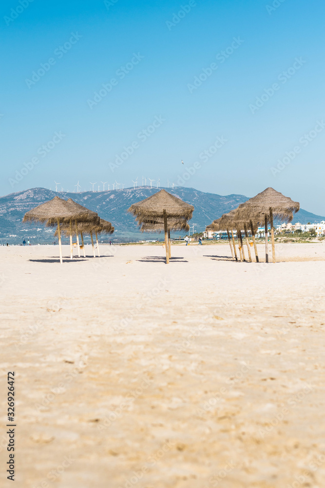 Set of umbrellas on the beach with mountain in the background