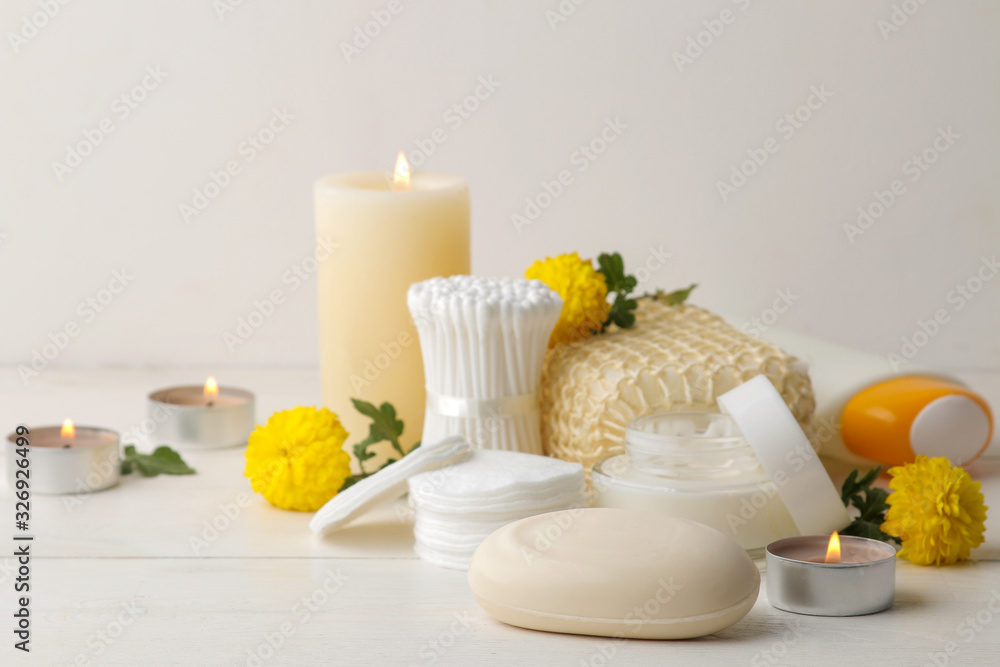 Various personal care products. Soap, Cotton pads, washcloth, sticks and yellow flowers on a white background. spa