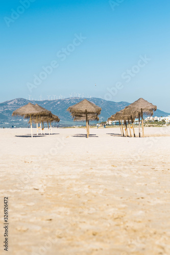 Set of umbrellas on the beach with mountain in the background © valebenifer