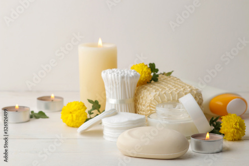 Various personal care products. Soap, Cotton pads, washcloth, sticks and yellow flowers on a white background. spa