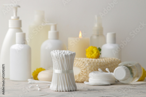 Various personal care products. Cotton pads close-up and sticks and yellow flowers on a white background