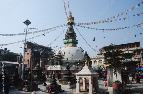 Vista amplia de la Stupa de Kathesimbu en Katmandú con cielo azul y palomas volando © Javi Sánchez