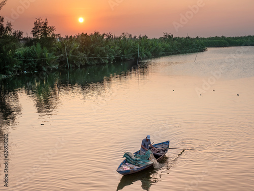 Fisherman on the Mekong river at sunset in Vietnam