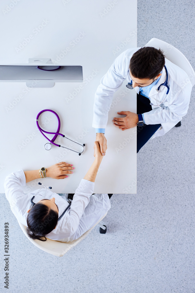 © khmelev - Professional muslim doctors handshaking at hospital. Flat lay, top view. Medical concept