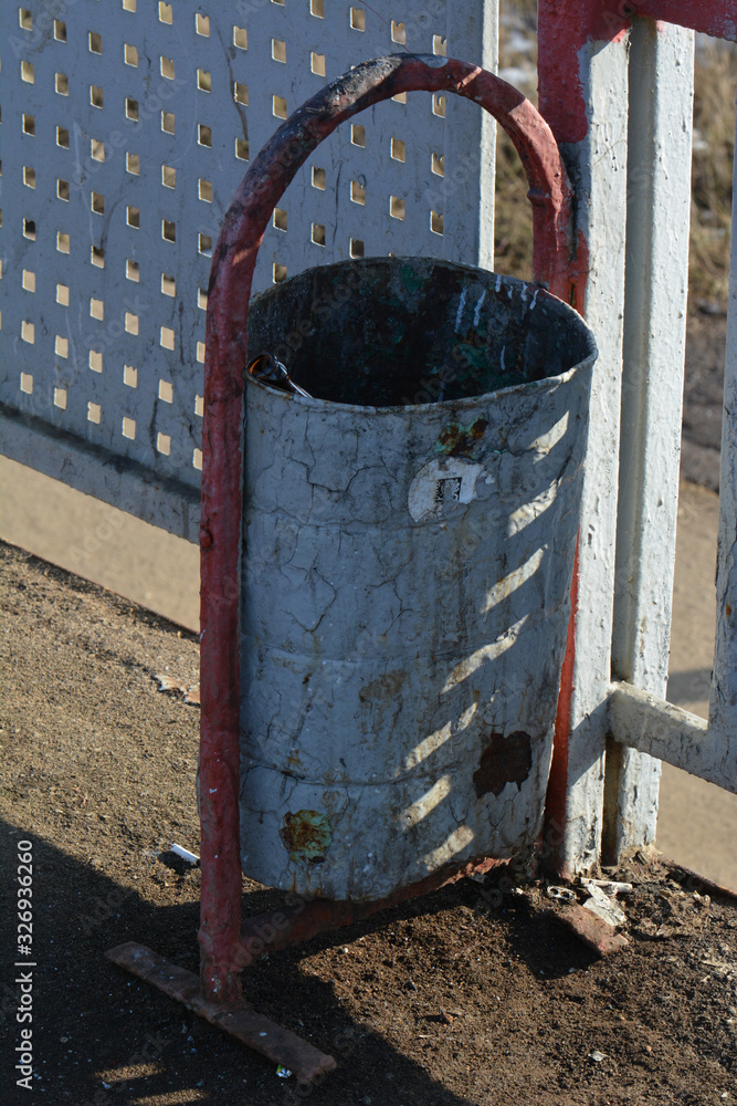 Old rusty urn in gray with an empty glass bottle inside Old rusty urn in gray with an empty glass bottle inside