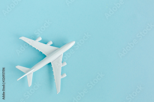 White model plane, airplane on blue background. Top view, flat lay. Travel, vacation concept.
