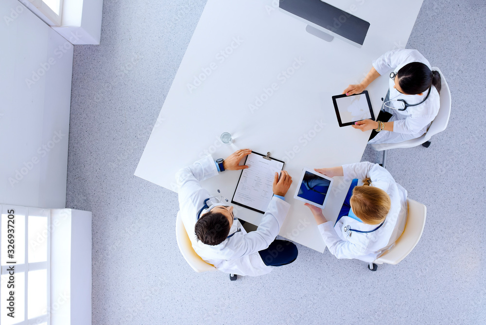 © khmelev - Group of doctors with gadgets in hospital , top view