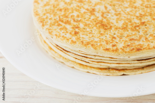 pancakes on plate on white wooden background