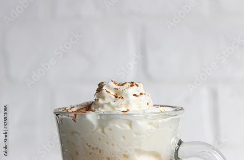 A view of a cappuccino in a cup, shot from above. The cup shows cream in the cup