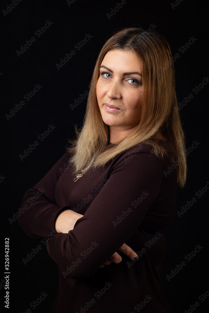 Portrait of a thirty-five-year-old woman on a black background in a dark dress Portrait of a thirty-five-year-old woman on a black background in a dark dress