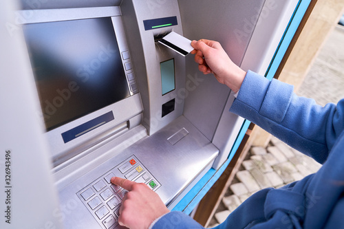 Tableau sur toile Person insert plastic credit card into atm bank and dials a PIN code on the keyb