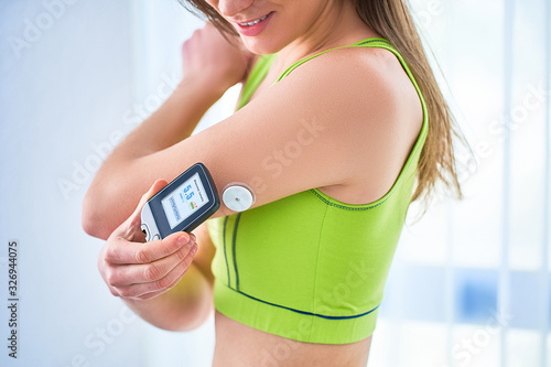 Woman diabetics control and checking glucose level with a remote sensor. Monitoring glucose levels without blood. Technology in diabetes treatment. Healthcare and medicine photo