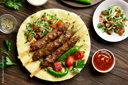 Turkish Adana Kebab with fresh vegetables on flatbread