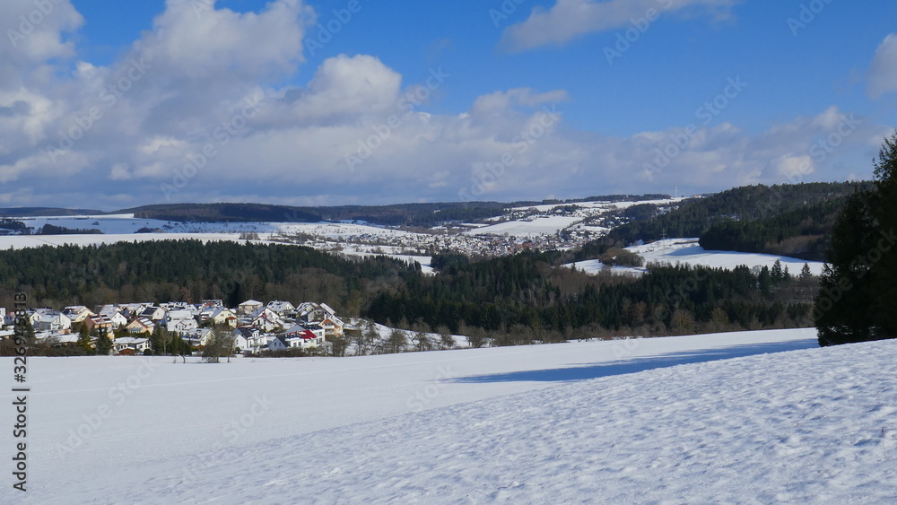 weiter Blick über sonnige Winterlandschaft mit Schnee, Wald und Dörfern im Schwarzwald