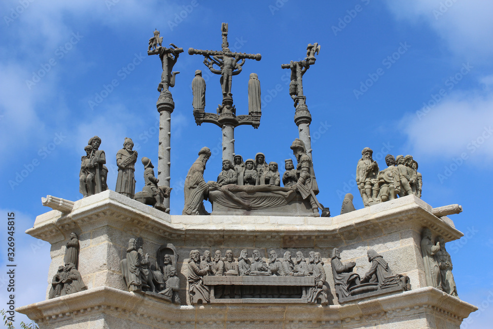 Obraz premium The newly restored 18th century sculpture on top of the triumphal arch or gateway of the dead at Pleyben parish close in Brittany, France.
