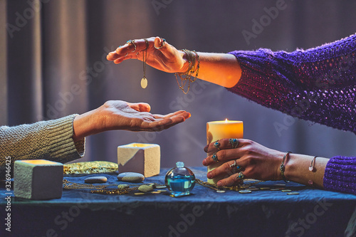 Fototapete Magic fortune teller woman during palmistry and divination around candles and ot