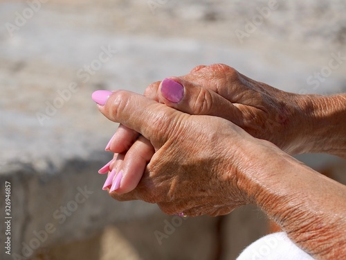 Closeup of the folded hands of a woman with pink fingernails © Stimmungsbilder1
