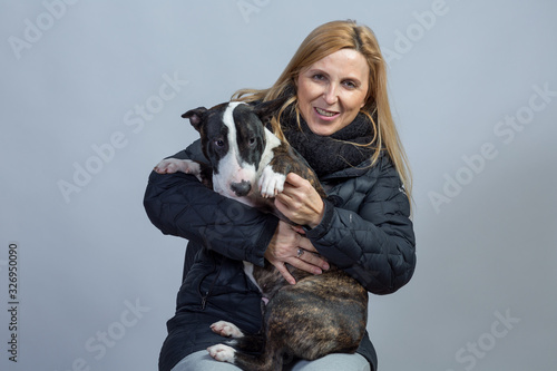 Fotografie Woman with her bull terrier bitch in affectionate situation