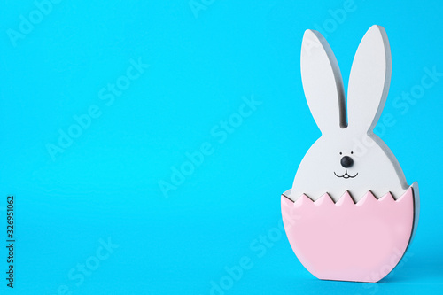 Bunny figure as Easter decor on blue background. Space for text