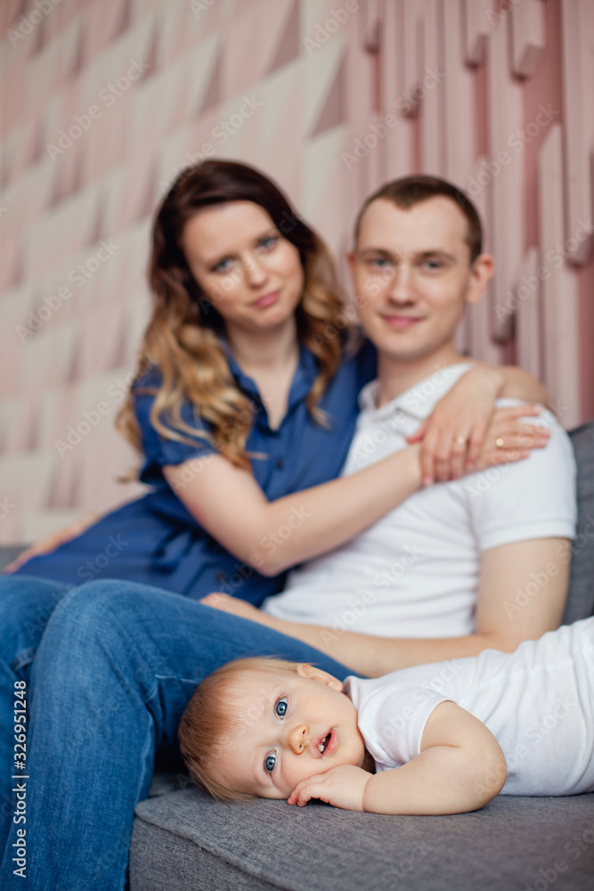 happy family of three relaxing on the sofa in the room happy family of three relaxing on the sofa in the room