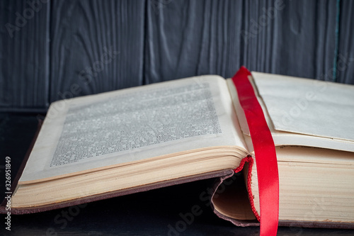 open old book with a red bookmark on a dark background